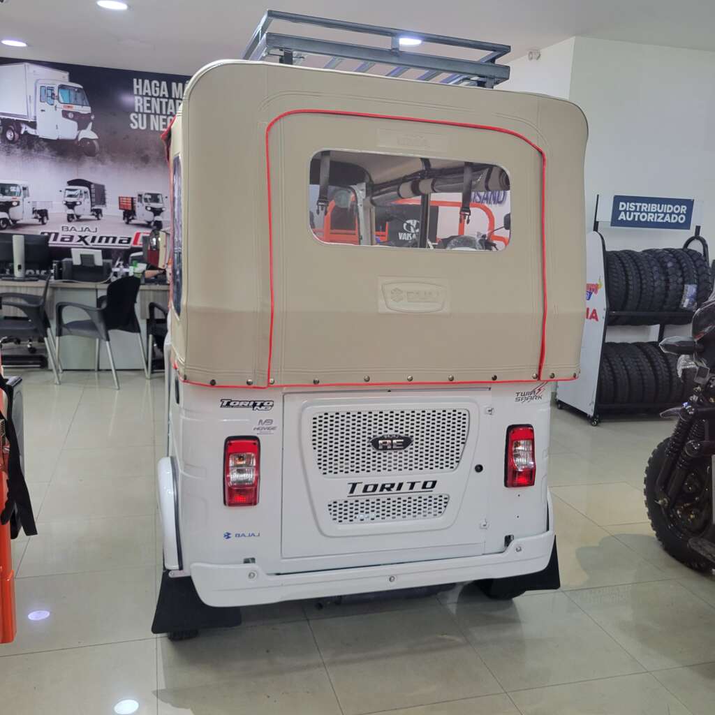 Vista trasera del Bajaj Torito Utilitario con personalización en carpa y asientos.